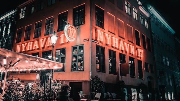 Exterior shot of Danish restaurant at dusk, glowing warmly against the evening sky.