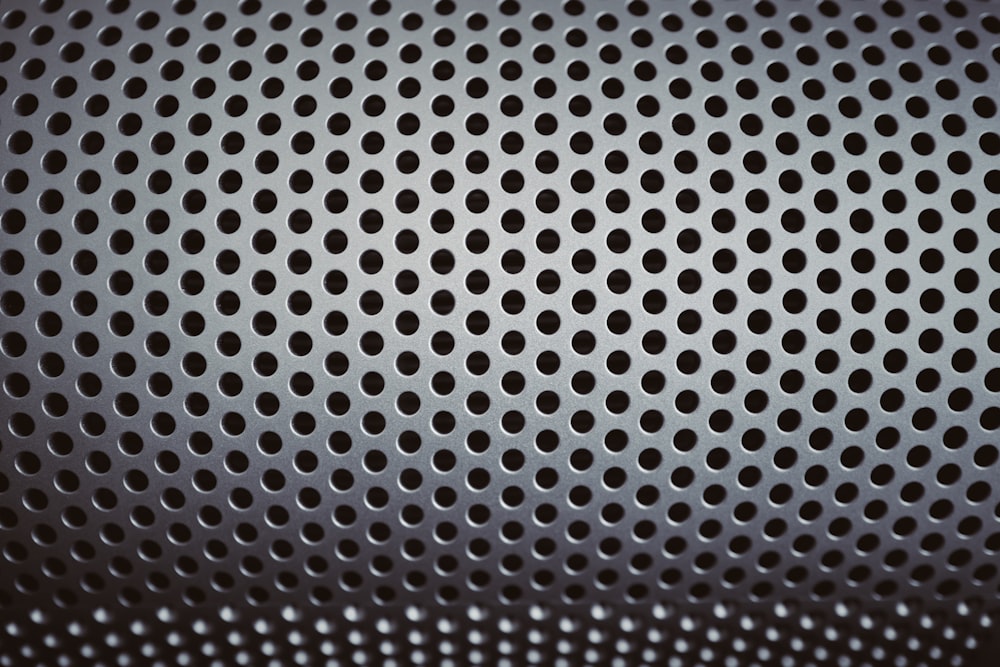 a close up of a metal surface with holes