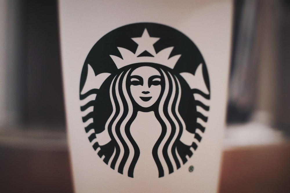 fotografía de enfoque selectivo de taza de Starbucks en blanco y negro