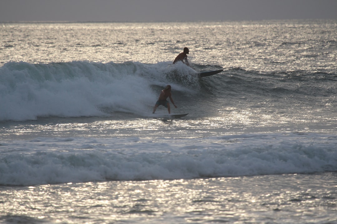 two person surfing during daytime