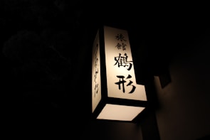 A close-up of a traditional Japanese talisman glowing softly in dim light.