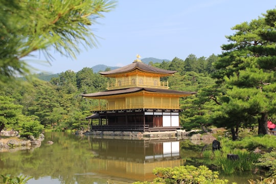 brown and beige pagoda by body of water during daytime in Kinkaku-ji Japan