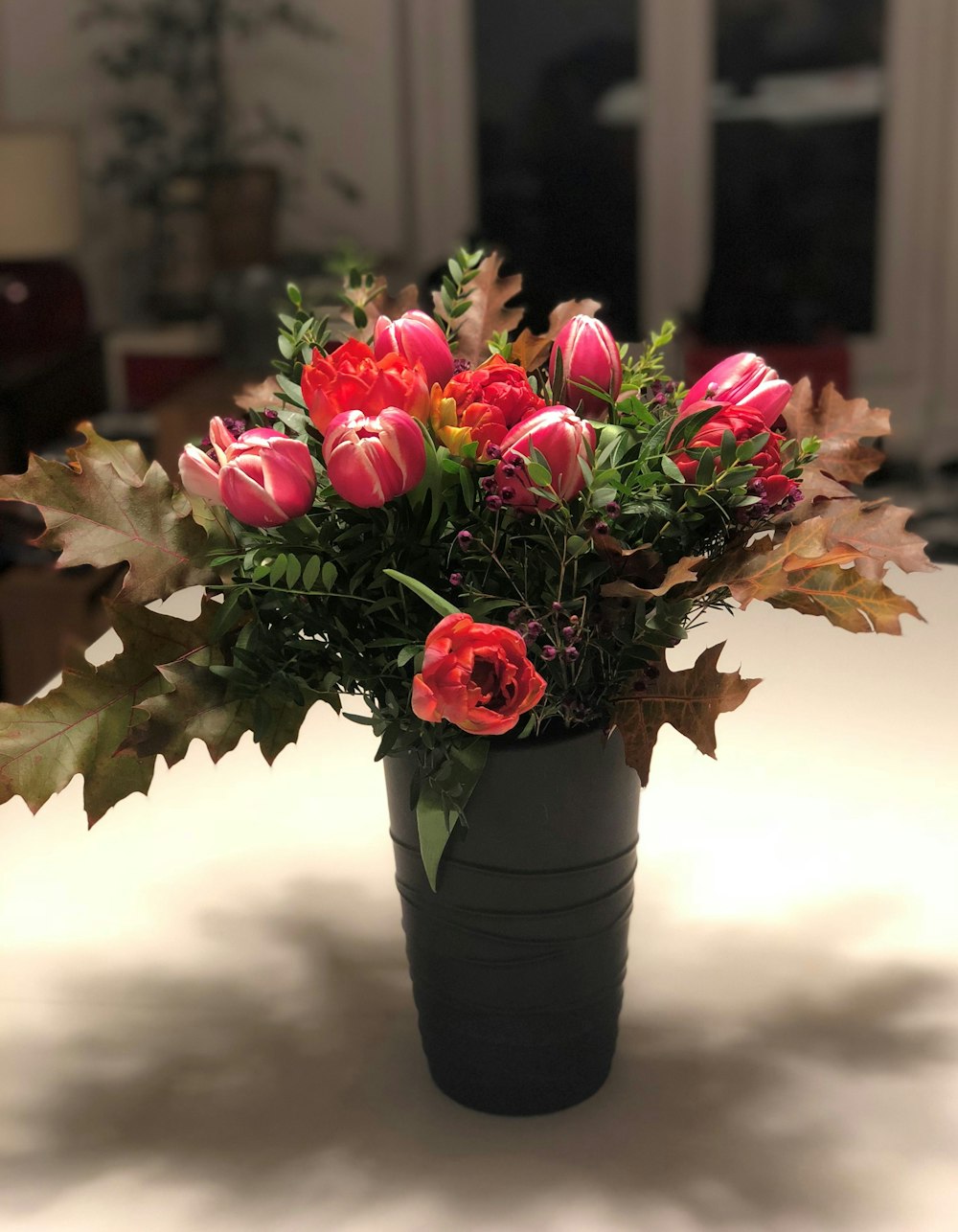 a vase filled with lots of flowers on top of a table