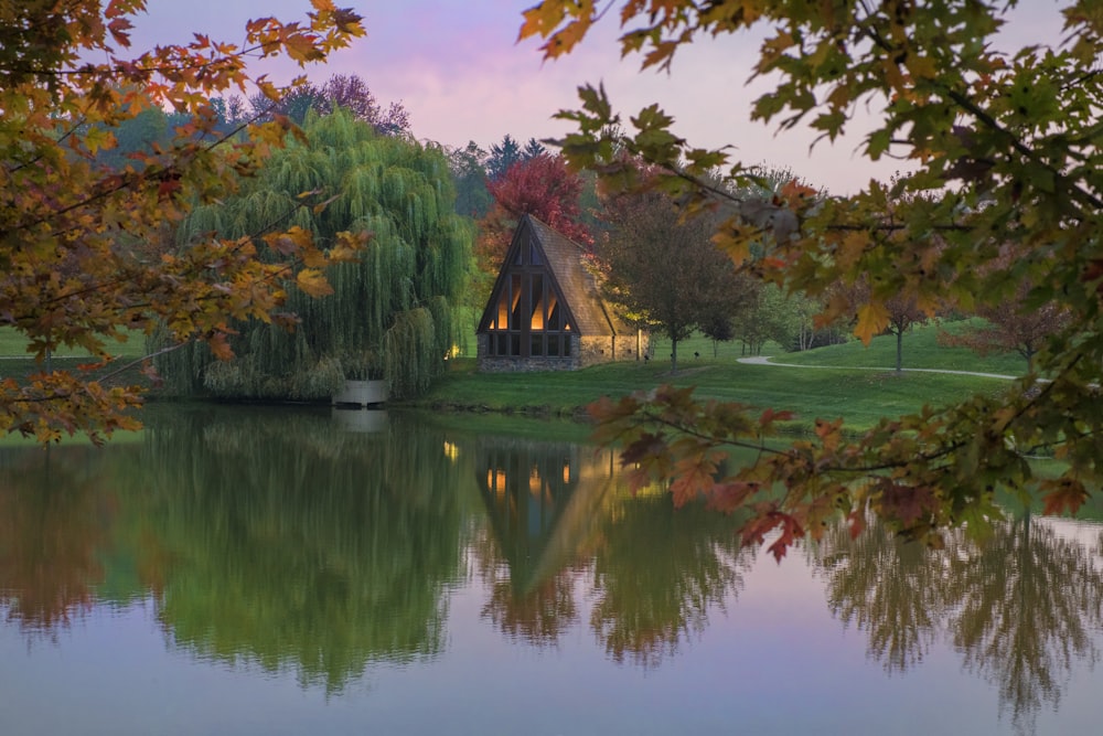 reflection of trees and house on body of water