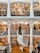 A spacious multi-level bookstore features floor-to-ceiling bookshelves filled with a diverse selection of books. The interior is marked by elegant architectural details, including tall white columns and a graceful spiral staircase connecting the levels. Several people are browsing the extensive collection, adding a lively yet tranquil atmosphere.