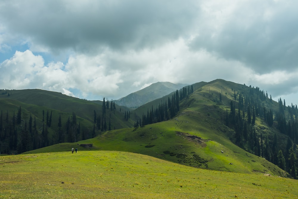 green mountain during daytime under white clouds