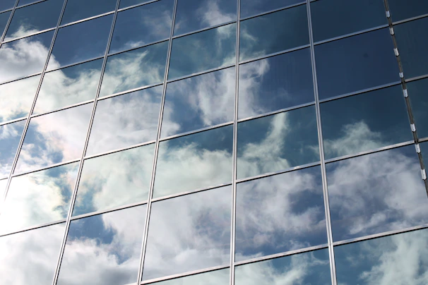 Reflection of a blue sky and clouds on freshly cleaned glass storefront windows.