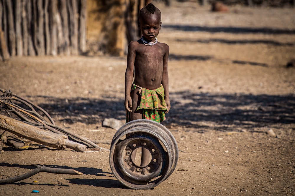 child standing beside chrome wheel