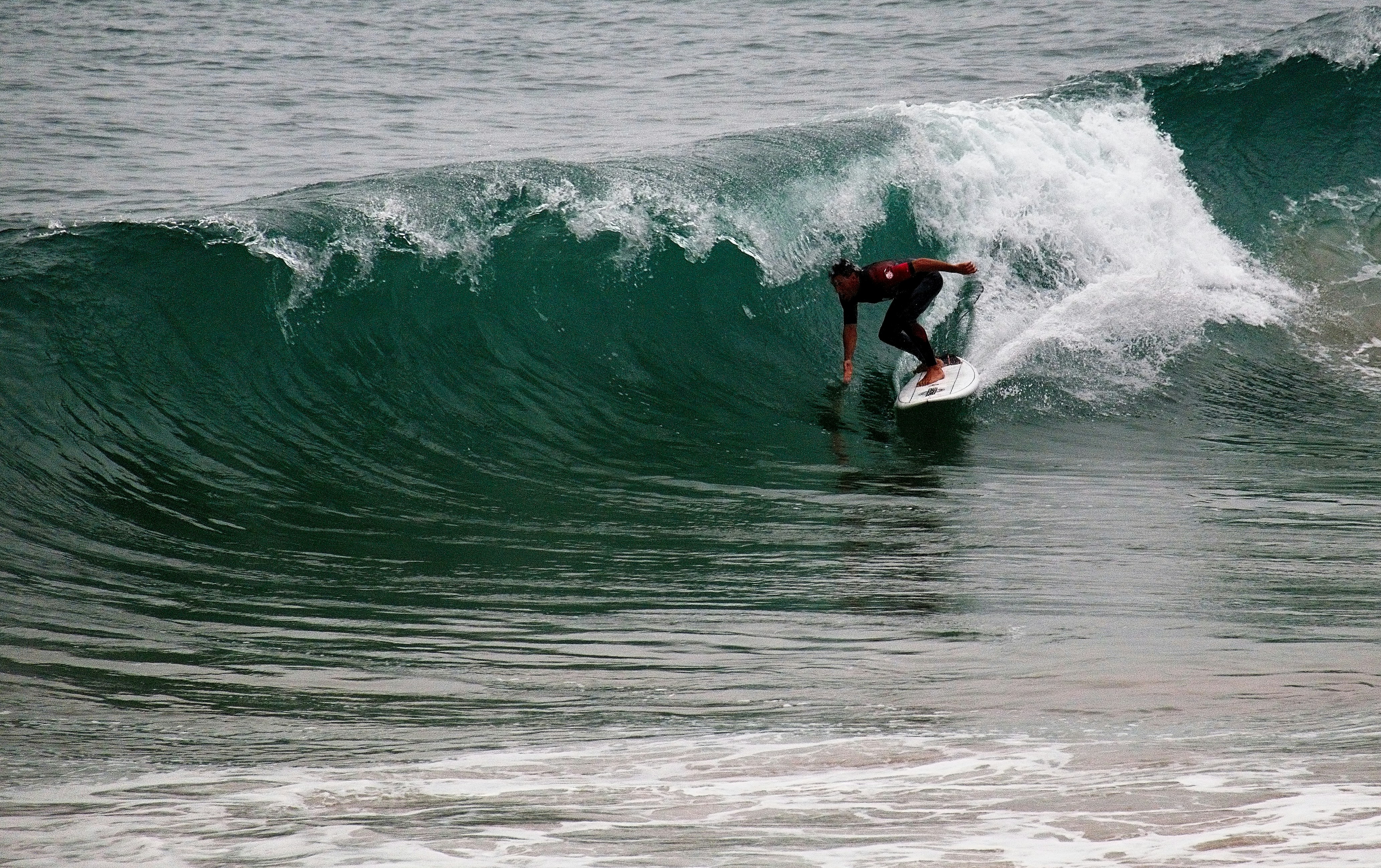 Surfing man touching water