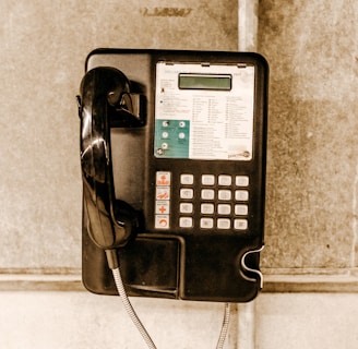 white and black coin operated telephone