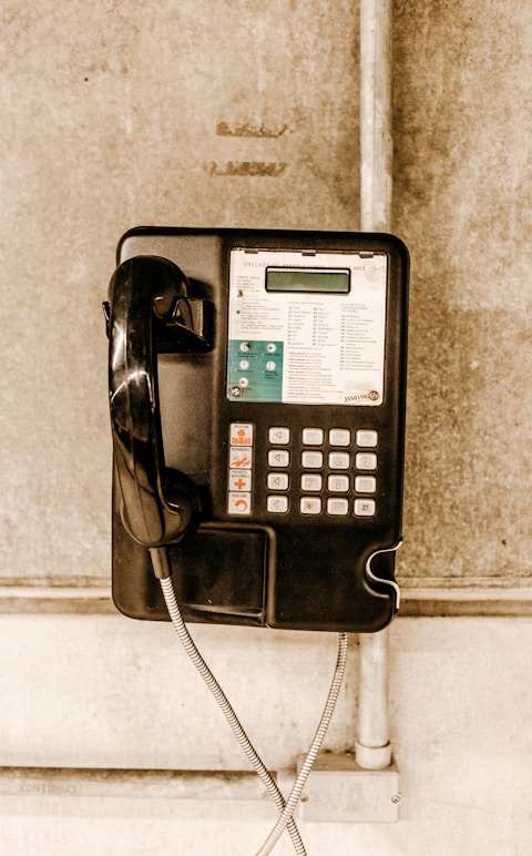 white and black coin operated telephone