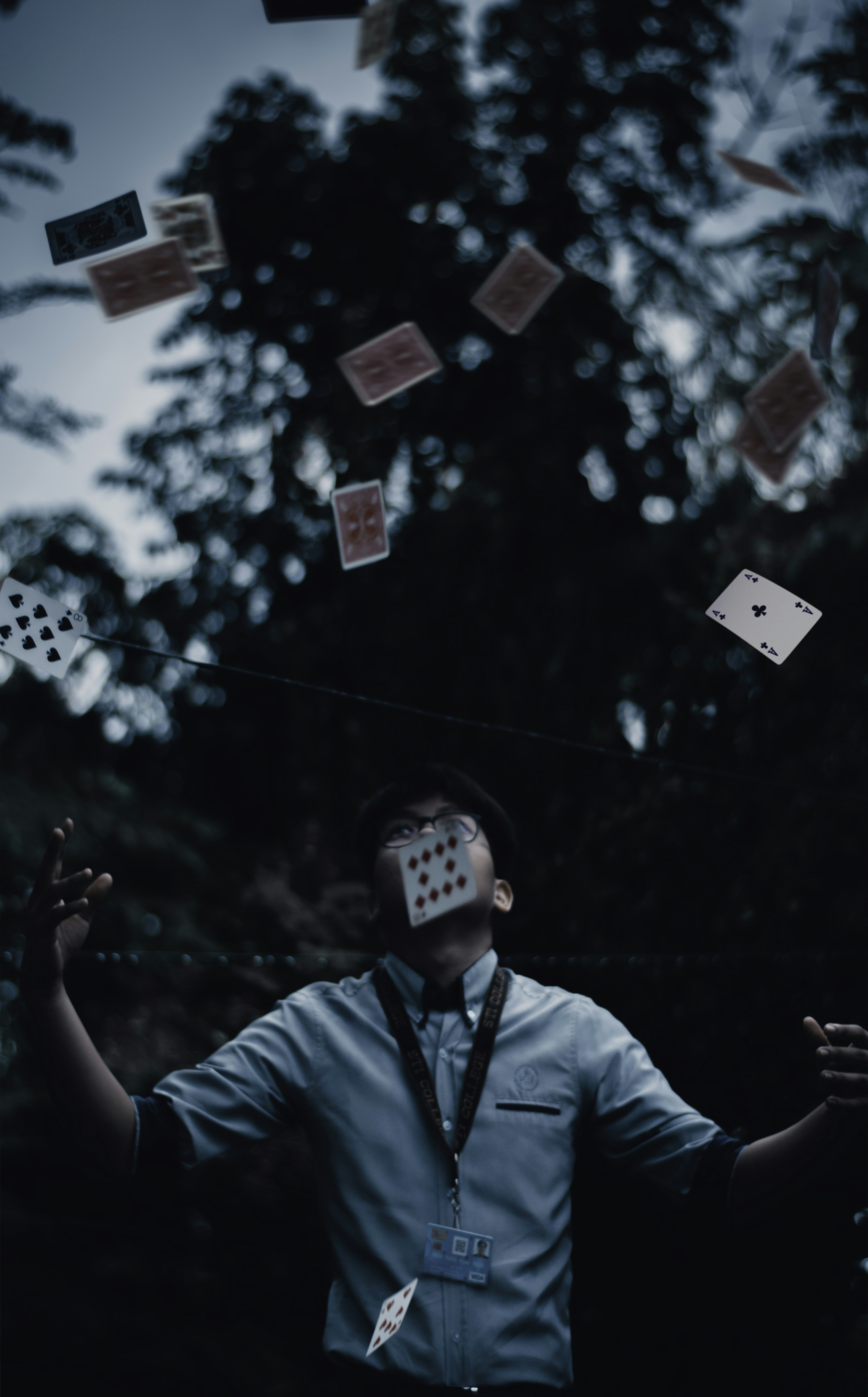 man in dress shirt juggling playing cards