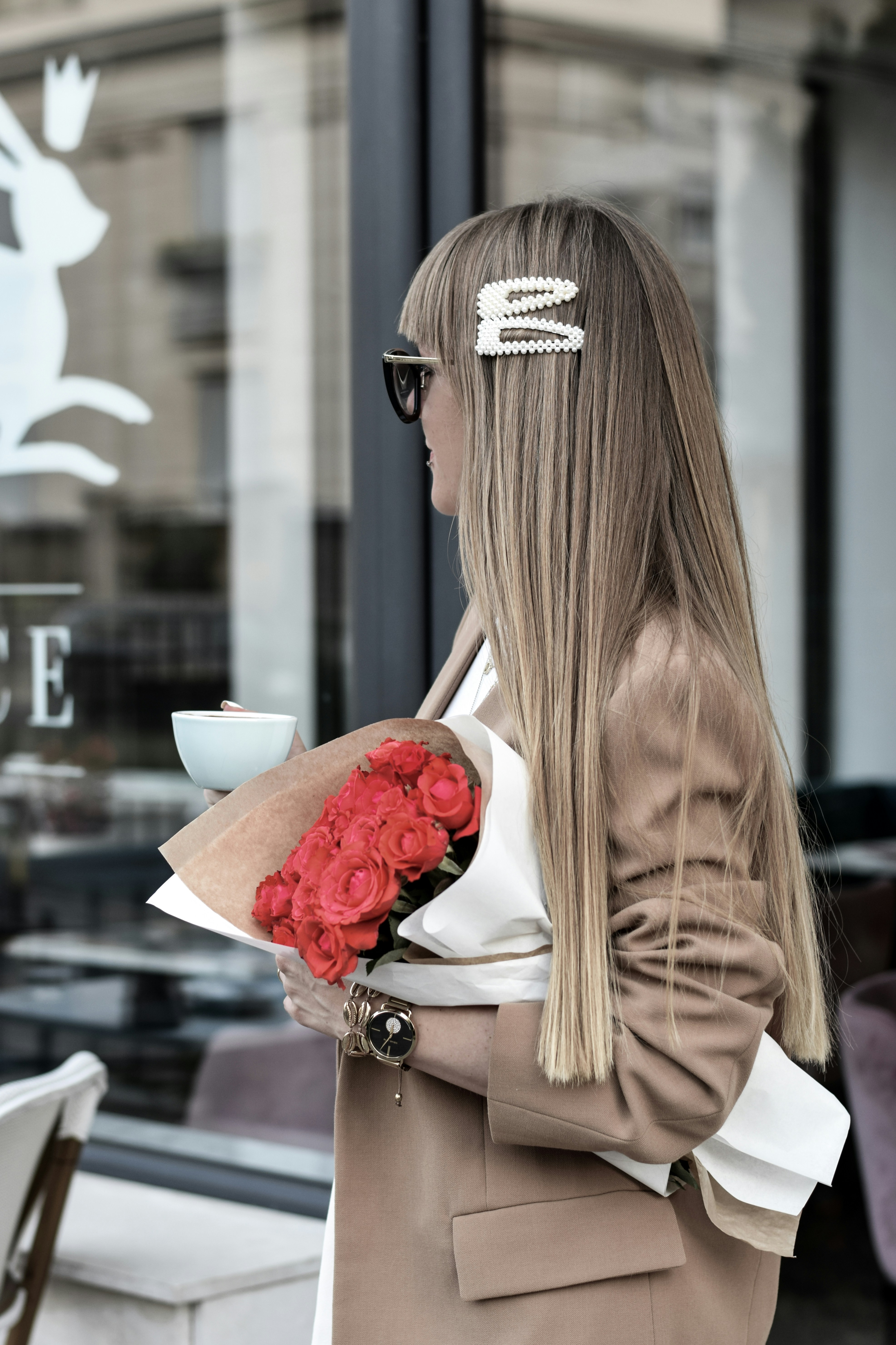 Frau steht und hält Rosenstrauß in der Hand