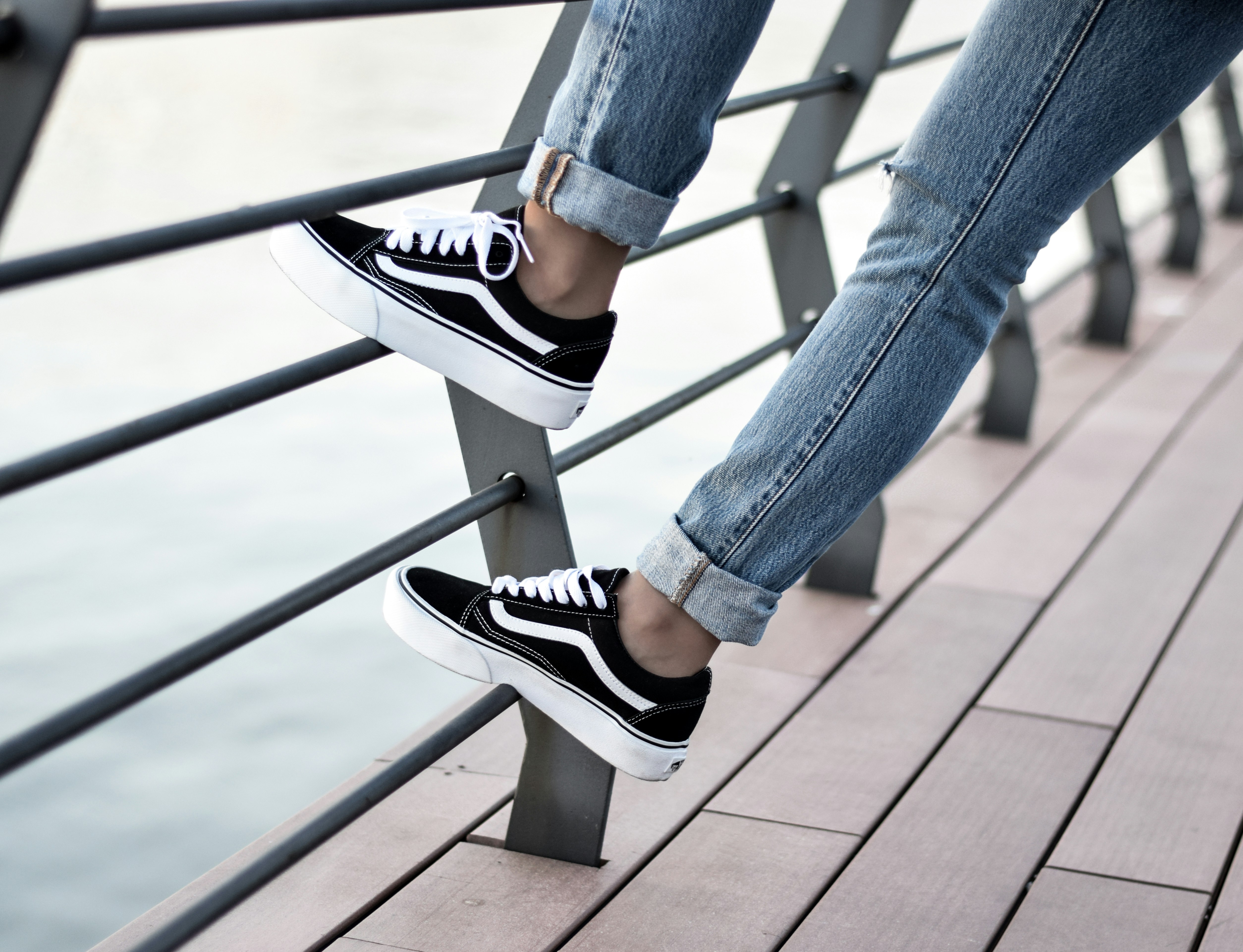 Person, die schwarze Low-Top-Turnschuhe von Vans trägt