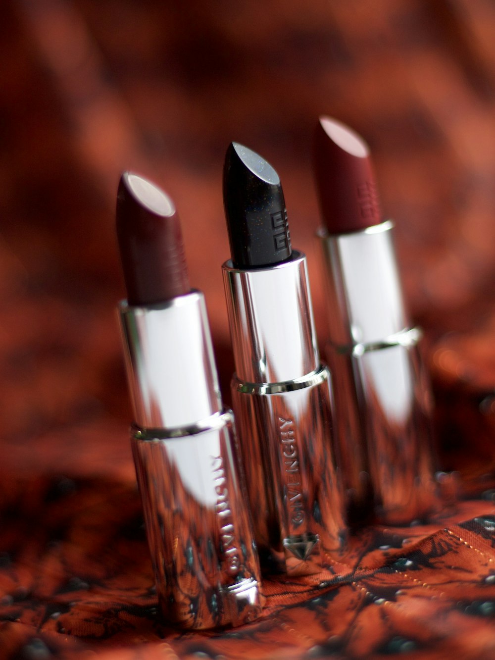 selective focus photography of three assorted-color lipsticks