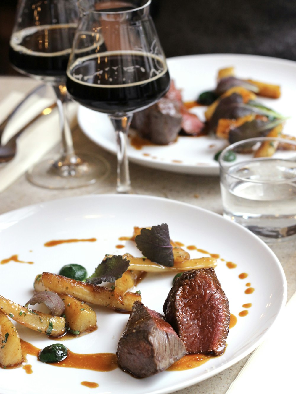 steak and vegetable on plate with wine