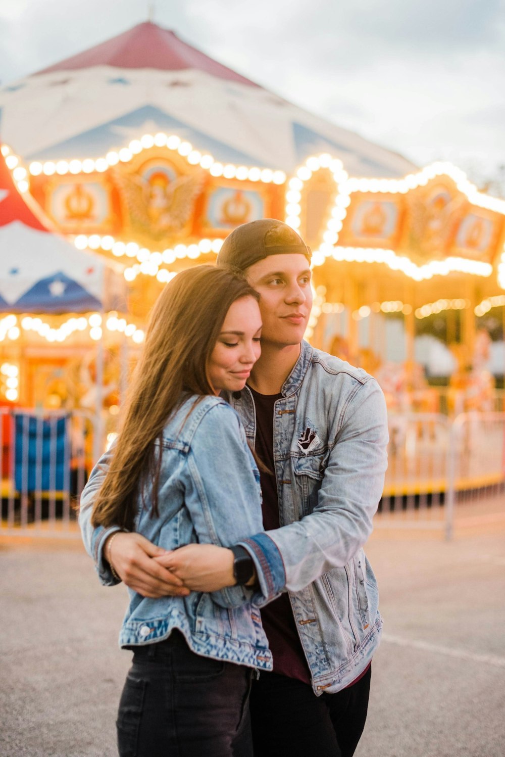 man hugging woman wearing blue denim jacket