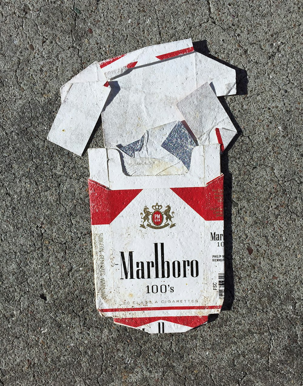 Caja de cigarrillos Marlboro roja sobre superficie gris