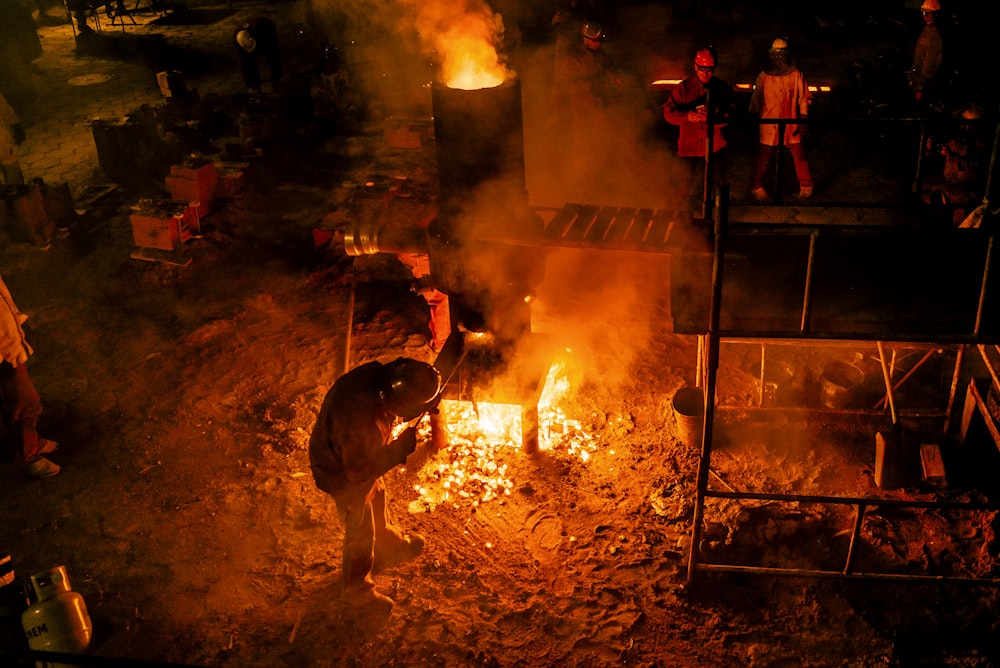 persone in piedi vicino alla fiamma