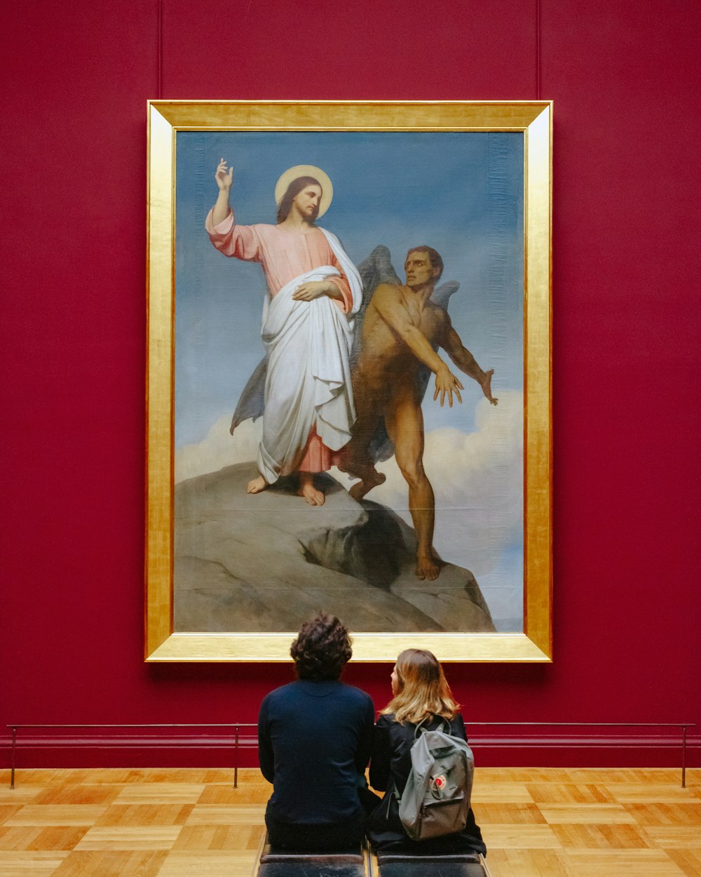 Mann und Frau sitzen vor dem Gemälde "Versuchungen Christi" von Botticelli