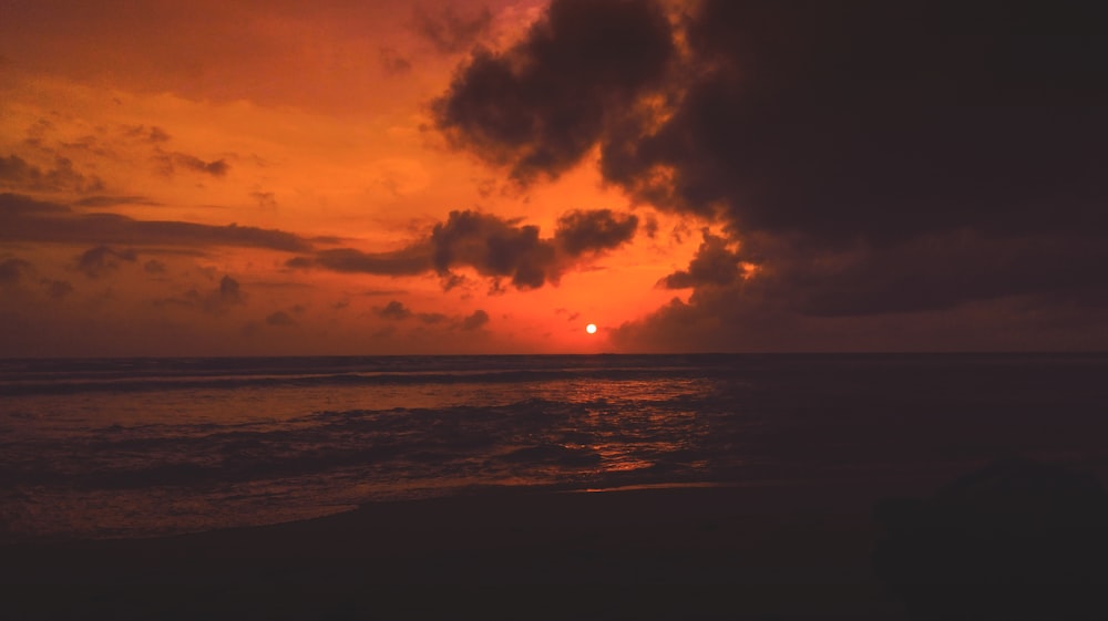 body of water under cloudy sky during golden hour