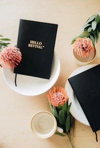 Softly lit flat lay of elegant journals and a gold pen resting on creamy textured paper.