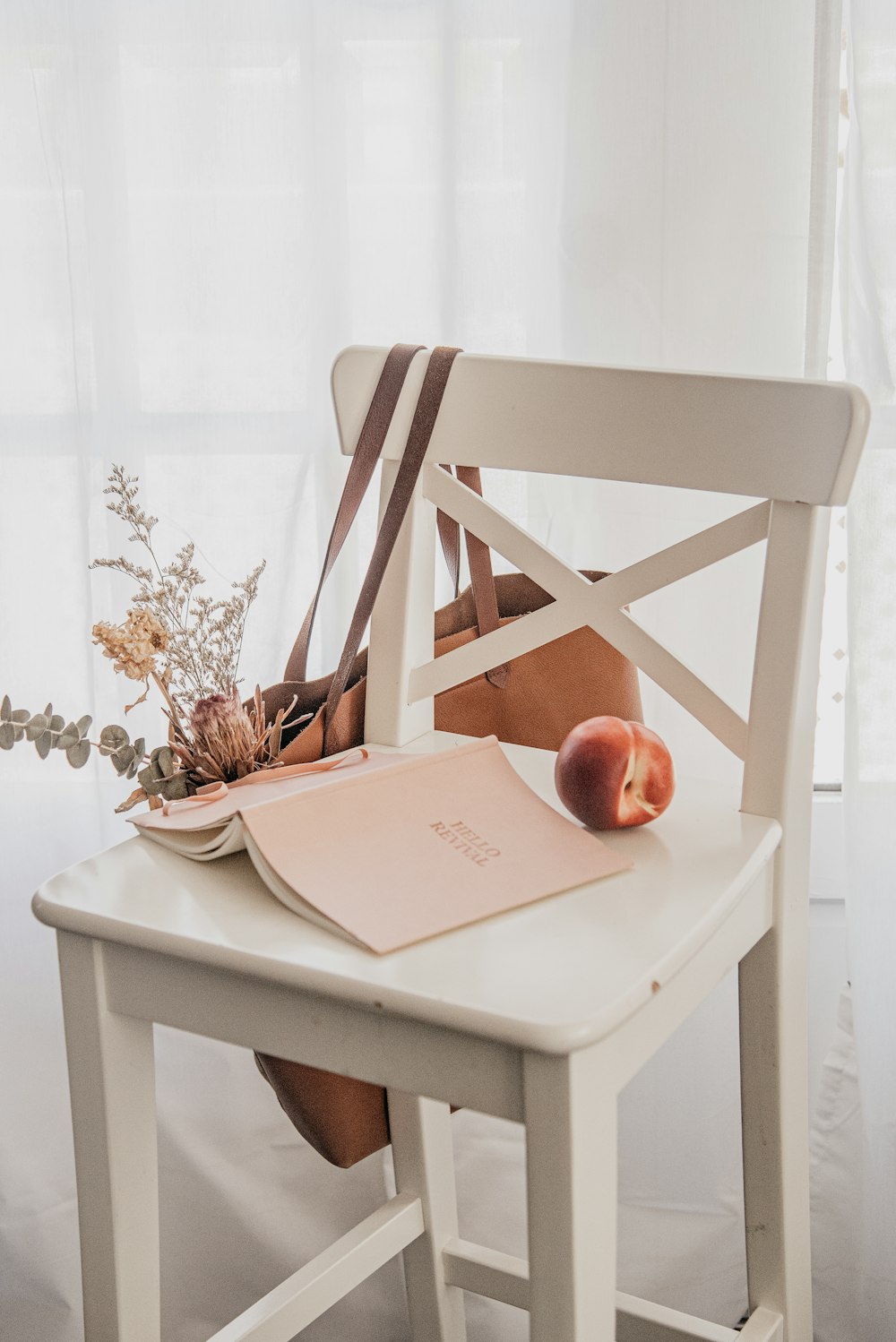 book and apple on white wooden chair
