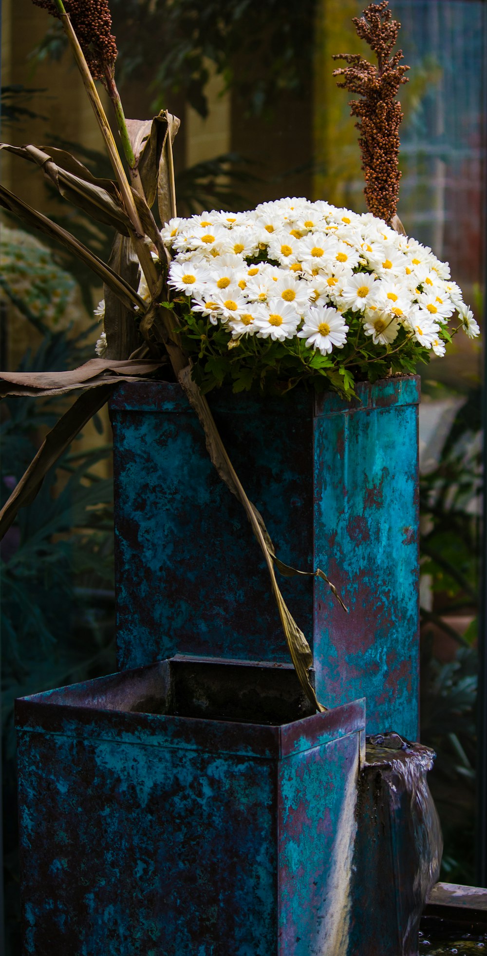 white flowers in blue metal vase