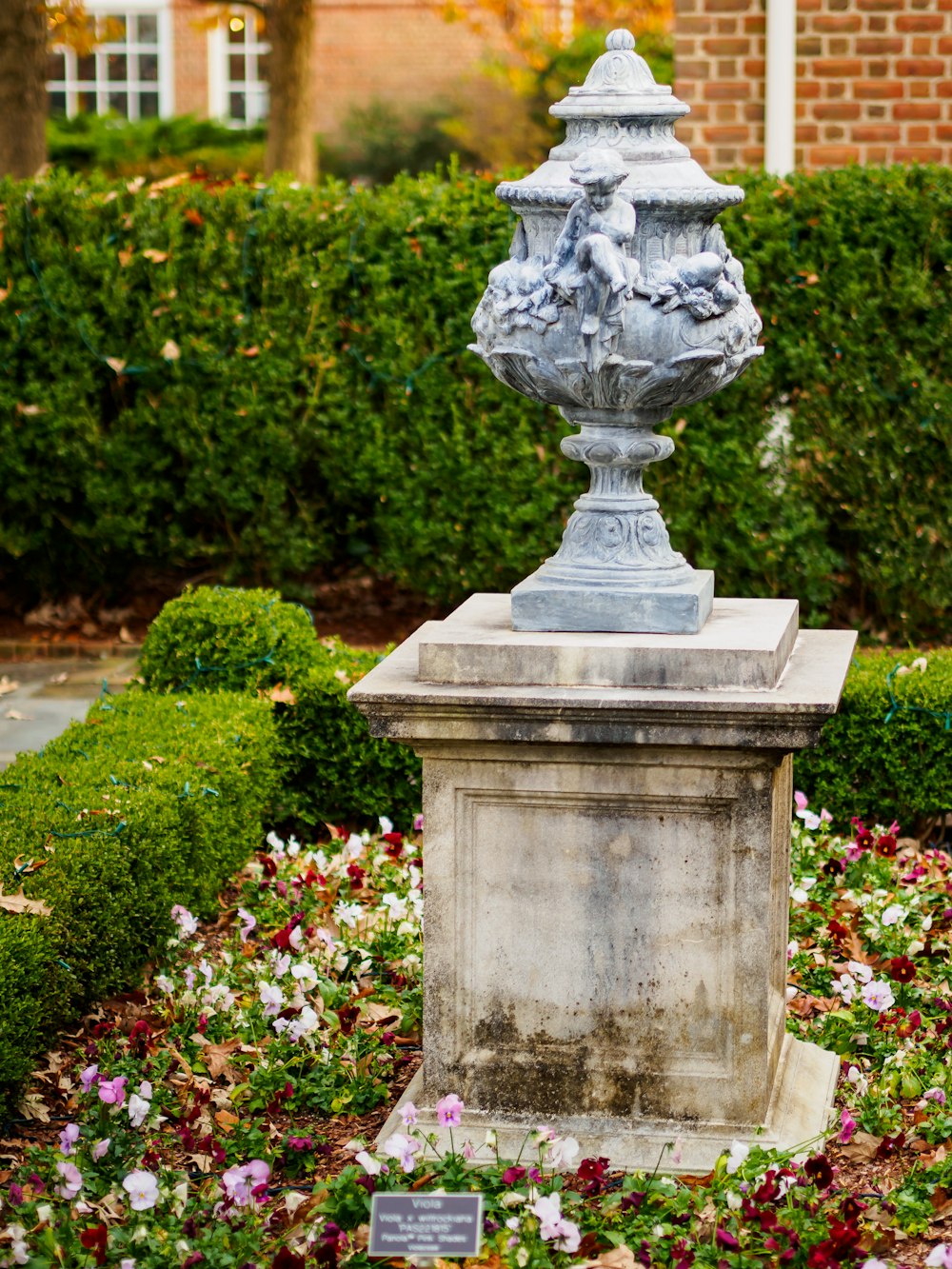 gray garden urn surrounded with flowers