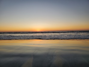 A serene image of a calm beach at sunset.