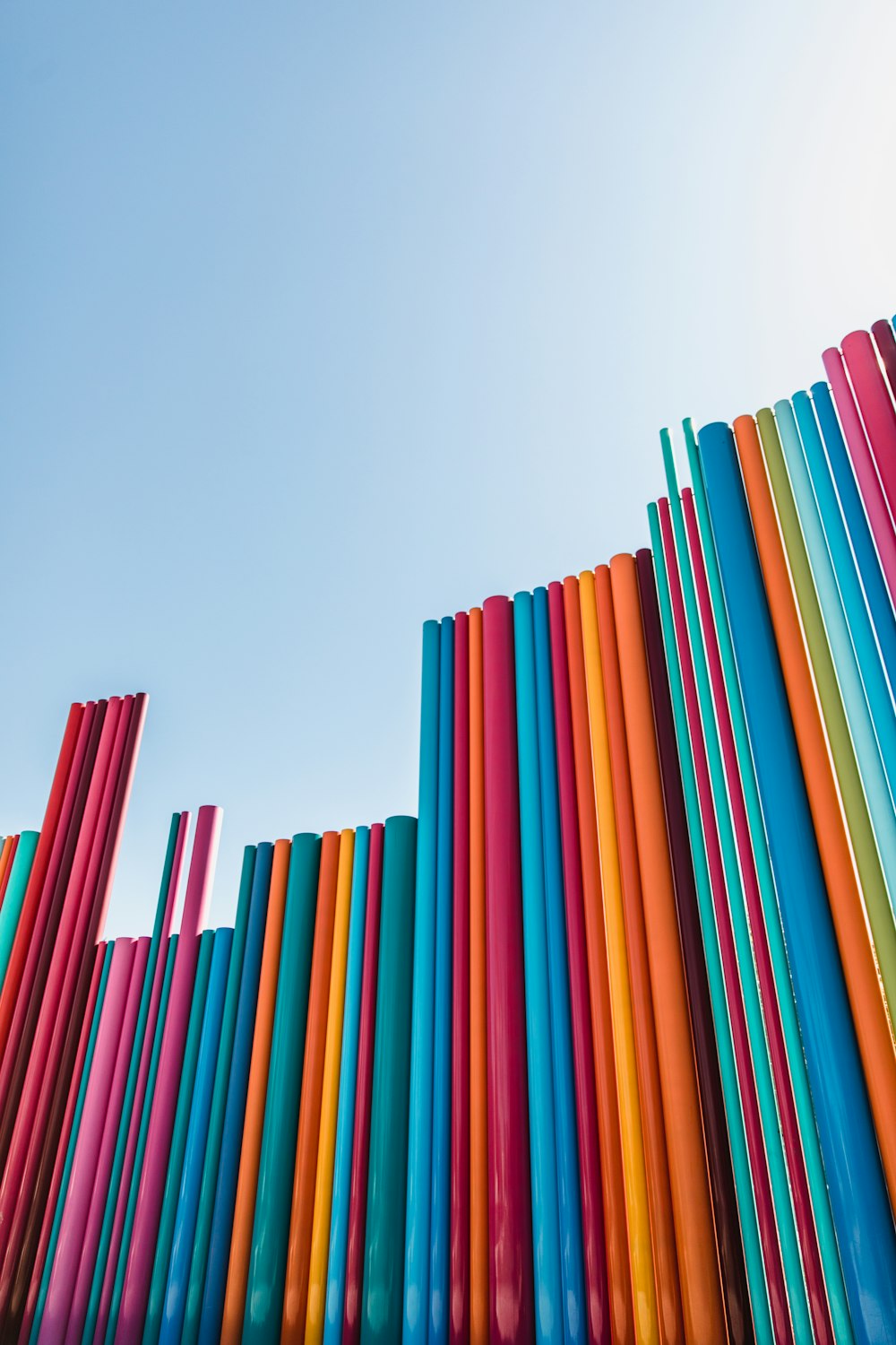 a rainbow colored wall with a blue sky in the background