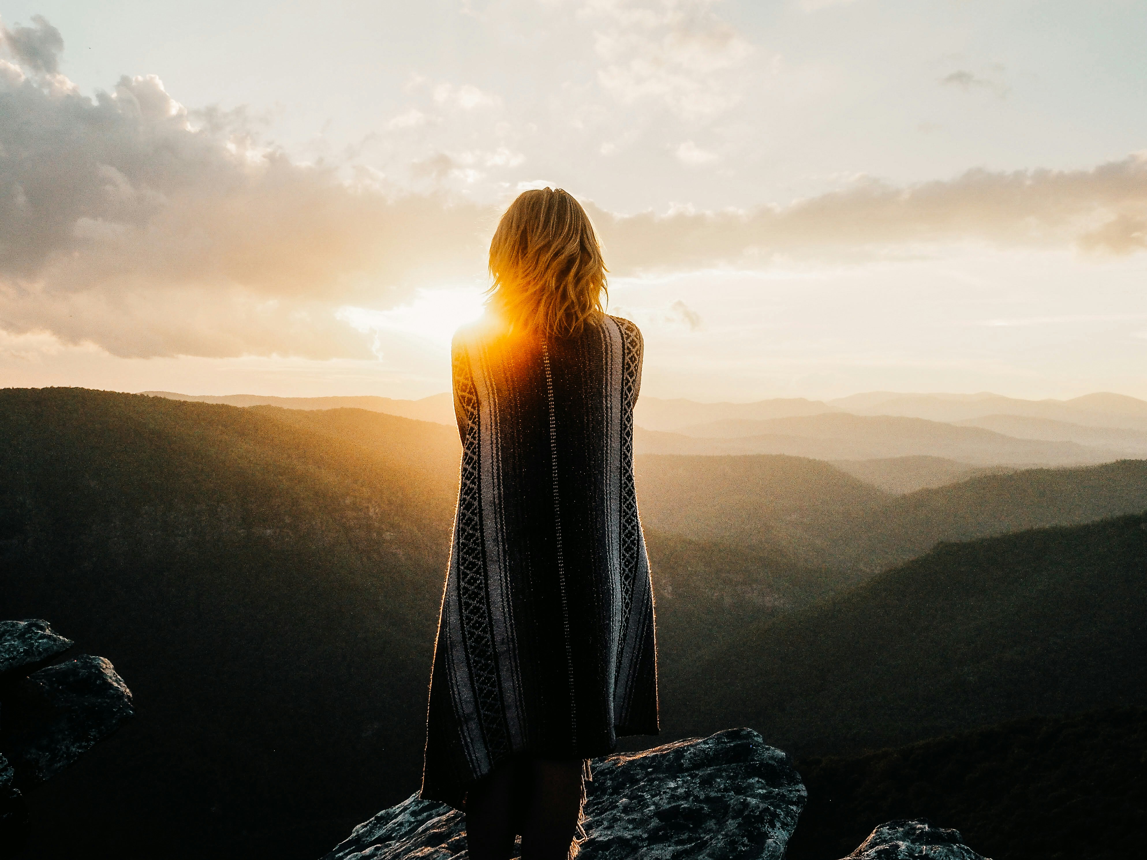 woman overlooking mountains during golden hour
