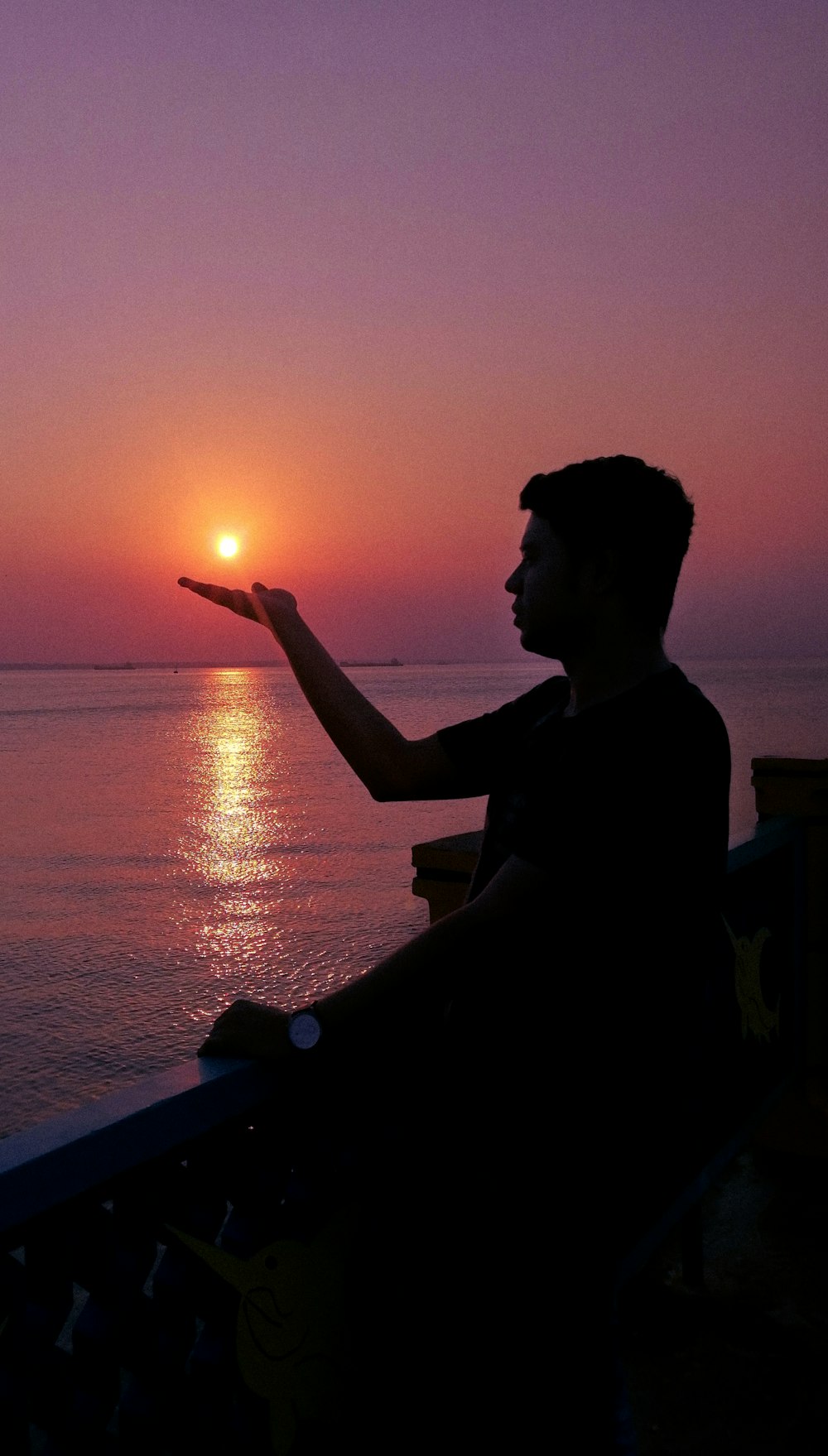 silhouette photography of man overlooking the ocean during golden hour