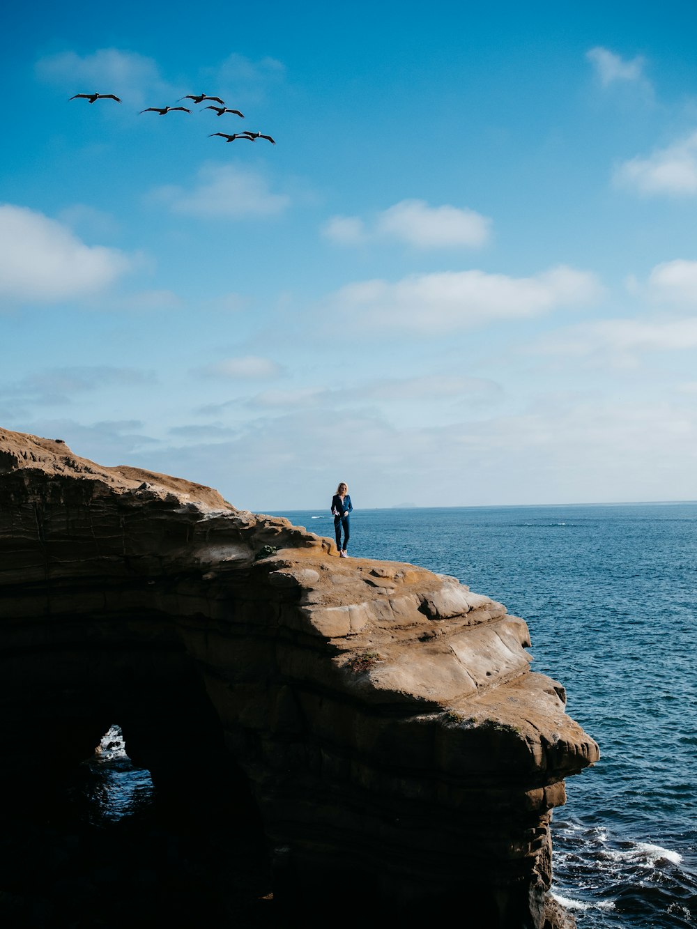 person standing on mountain near ocean during daytime