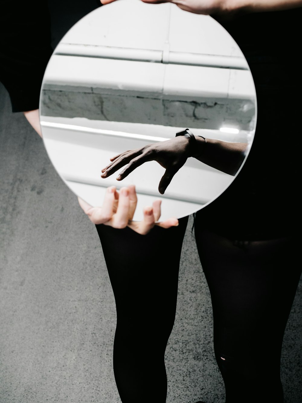 person holding round mirror