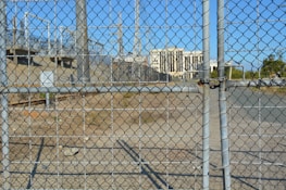 Electric fence installation in progress around a secure property.