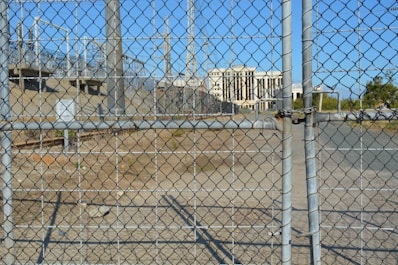 Close-up of a fenced industrial plot with visible utility connections.
