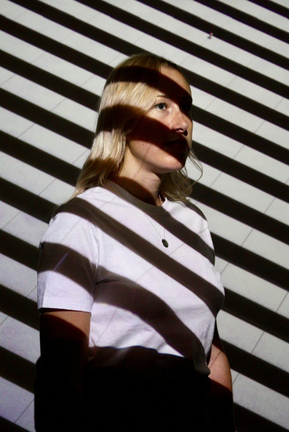 woman in white t-shirt beside wall