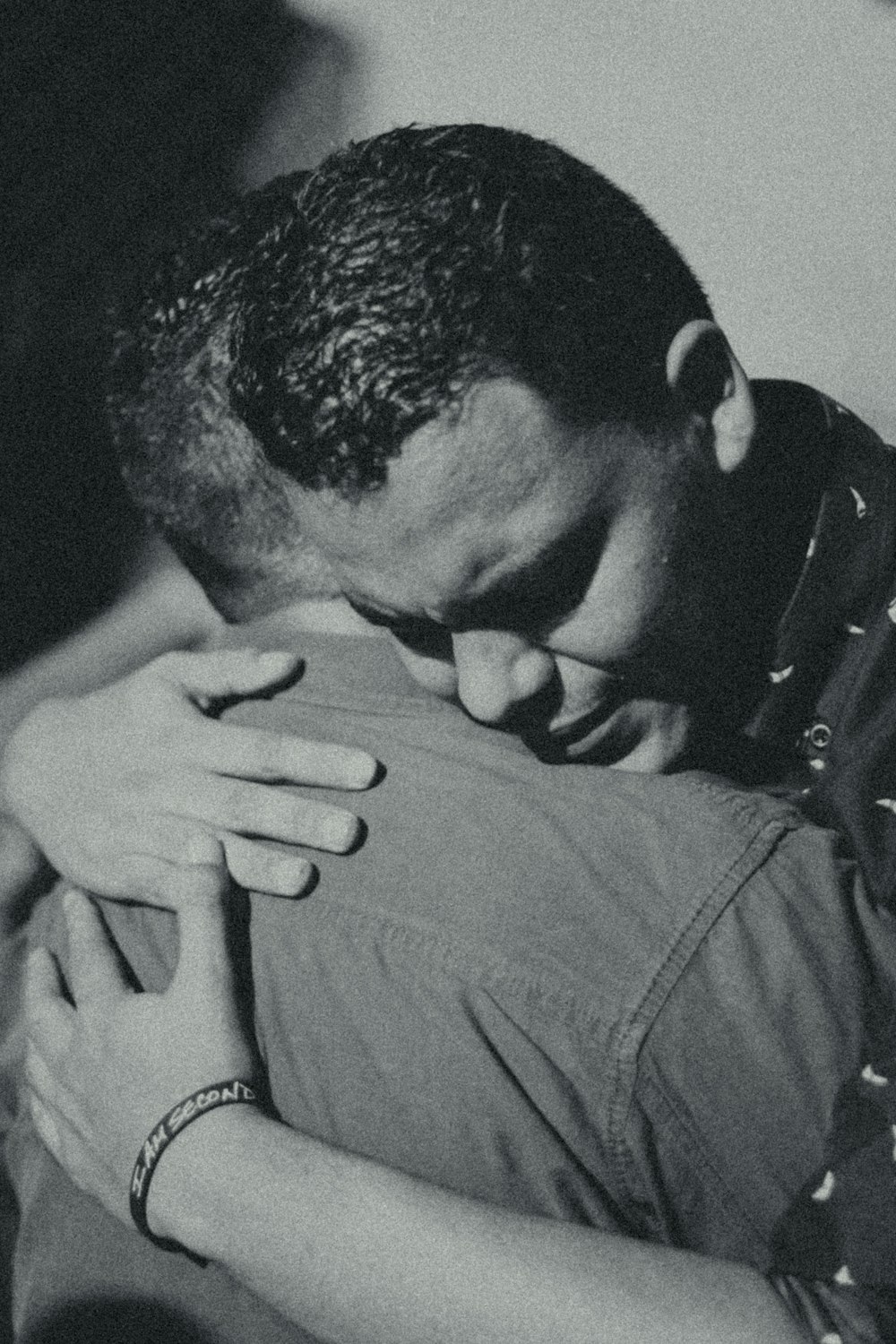 grayscale photography of two men hugging