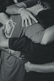 grayscale photography of men doing group hug