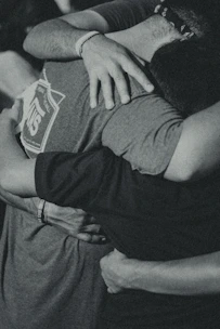 grayscale photography of men doing group hug