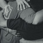 grayscale photography of men doing group hug