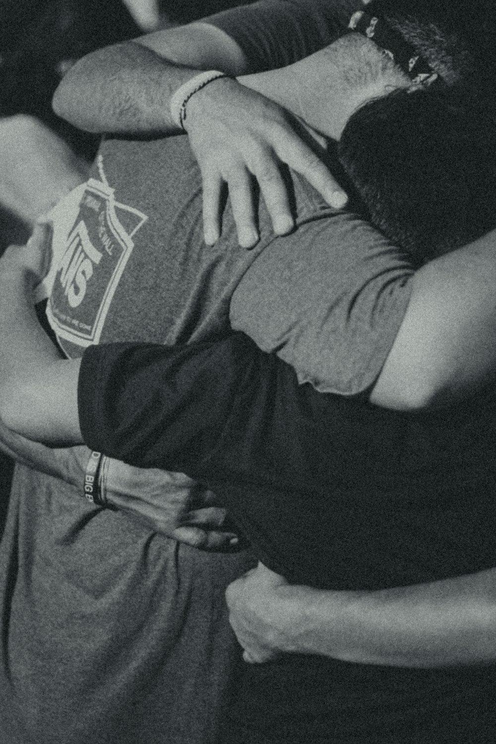 그룹 포옹을 하는 남자의 회색조 사진