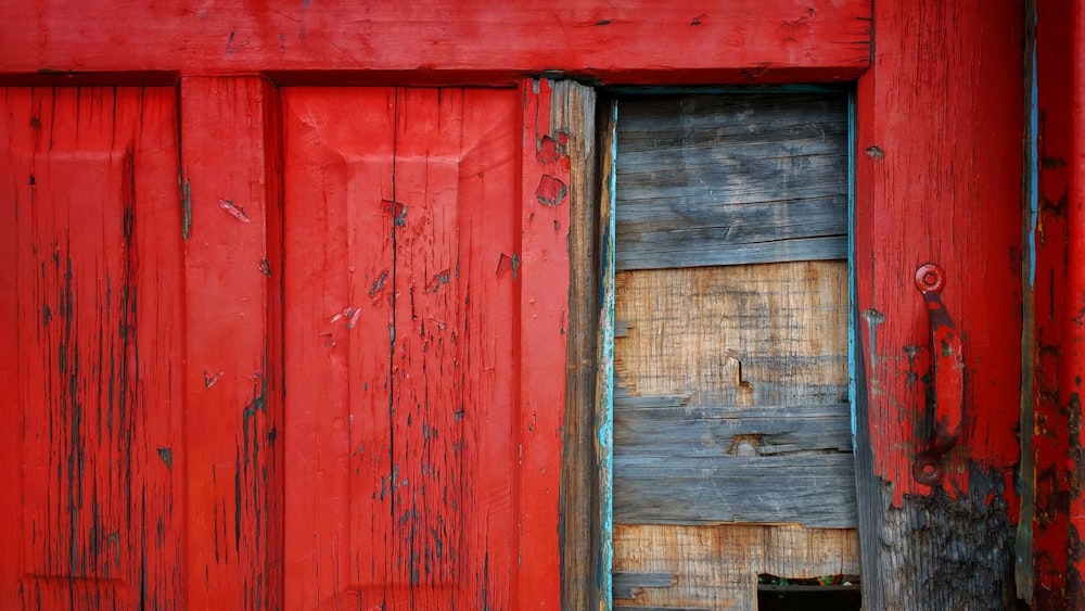 a cat is sitting in the doorway of a red building