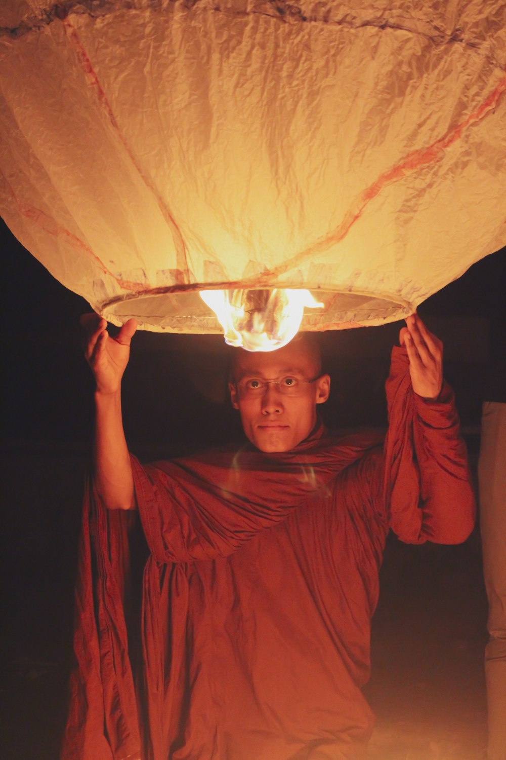 man holding a lighted sky lantern