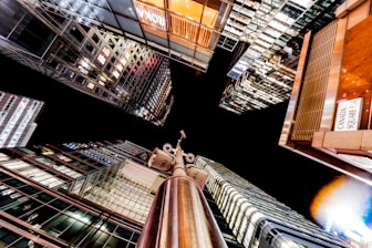 Nighttime cityscape with glowing surveillance cameras watching over buildings