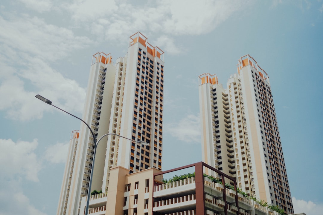 low-angle photo of white highrise buildings under blue loudy sky