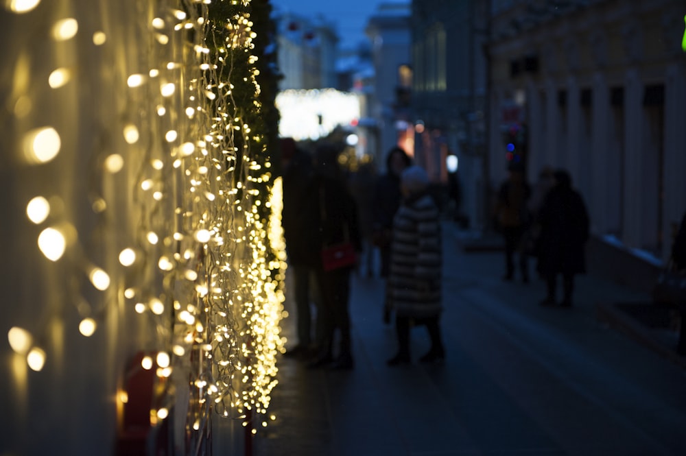 a group of people walking down a street at night