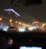 A nighttime cityscape with a J&J Transportation vehicle smoothly driving through well-lit streets.