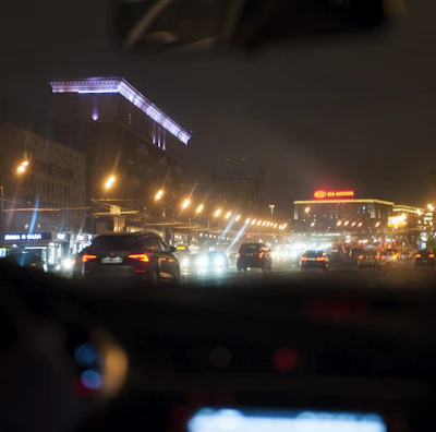 A nighttime cityscape with a J&J Transportation vehicle smoothly driving through well-lit streets.